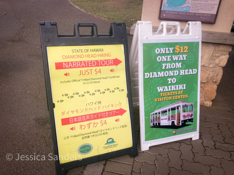 Signs at Diamond Head State Monument indicating public transportation availability to Waikiki