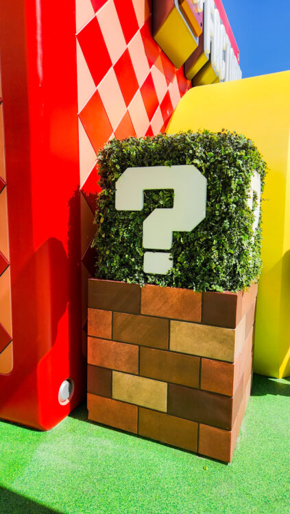A shrub in Super Nintendo World in Universal studios Hollywood. shaped like a cube with a question mark on each side
