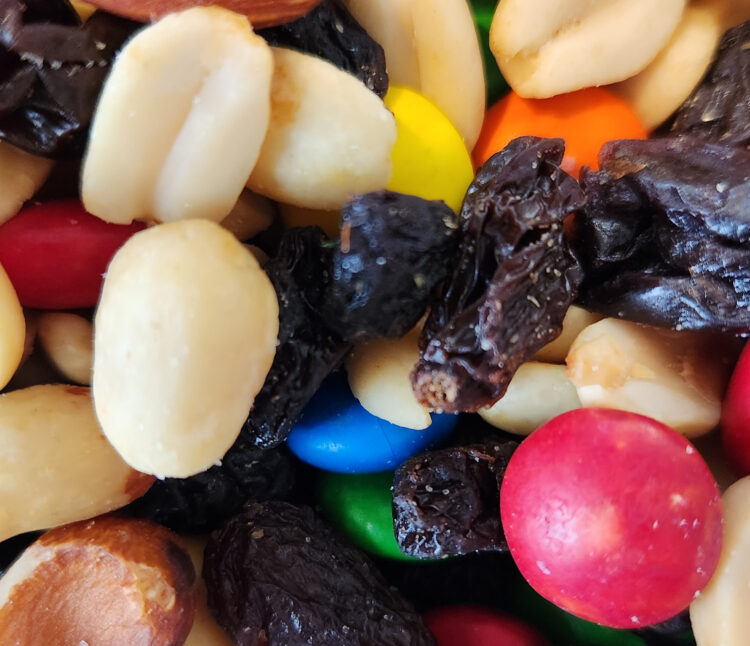 Close up of trail mix with nuts, raisins, and candies as a road trip snack