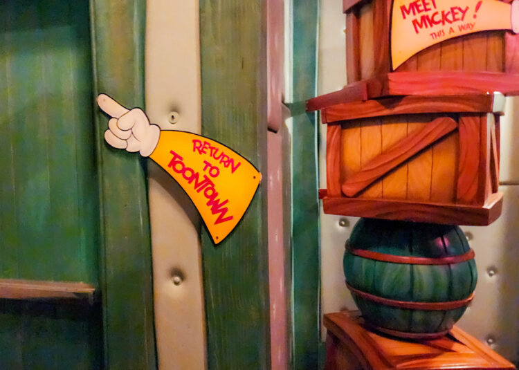 Sign in Mickey's house, pointing to a door saying "Return to Toontown" with a second sign pointing to another hallway that says "Meet Mickey! This A Way"